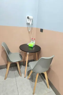 a table and two chairs sitting next to a table at Qingqing Hotel Pasay Manila near MOA in Manila