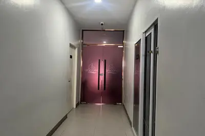 a hallway with a purple door in a building at Qingqing Hotel Pasay Manila near MOA in Manila