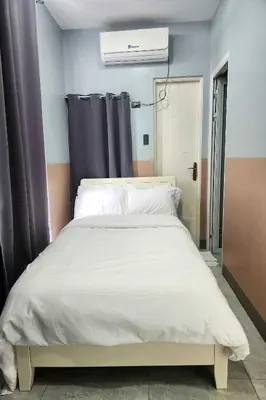 a bedroom with a bed with a white comforter at Qingqing Hotel Pasay Manila near MOA in Manila