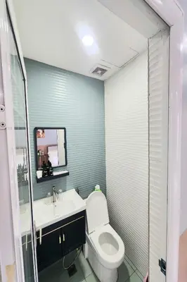 a bathroom with a toilet and a sink and a mirror at Qingqing Hotel Pasay Manila near MOA in Manila