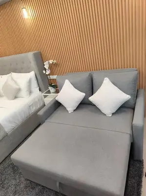 a couch with pillows on it in a room at Georgia Luxe Suite at Shore 2 MOA in Manila