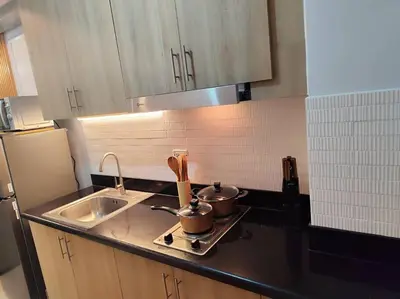 a kitchen with two pots on a stove next to a sink at Georgia Luxe Suite at Shore 2 MOA in Manila