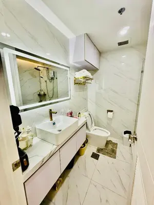 a white bathroom with a sink and a toilet at Gina Staycation Condo Unit in Manila