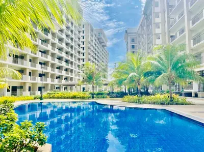 an image of a swimming pool in front of buildings at Gina Staycation Condo Unit in Manila