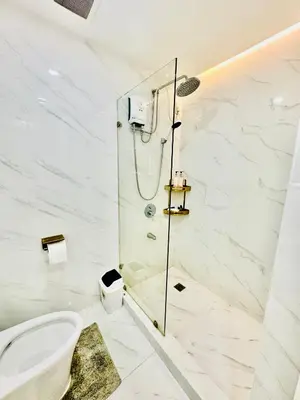 a bathroom with a shower and a toilet at Gina Staycation The Atherton DMCI Parañaque in Manila