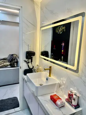 a white bathroom with a sink and a mirror at Gina Staycation The Atherton DMCI Parañaque in Manila