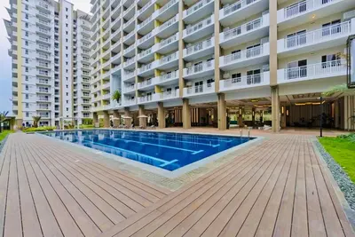 a swimming pool in front of a large apartment building at Gina Staycation The Atherton DMCI Parañaque in Manila