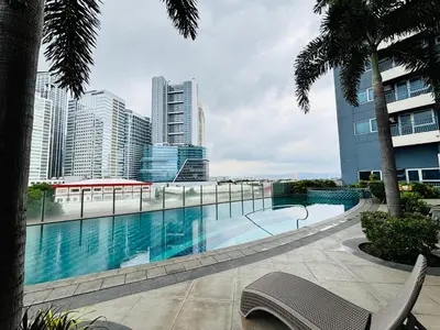 a swimming pool in a city with tall buildings at LA Amore Place Aspire Tower Nuvo City Libis in Manila
