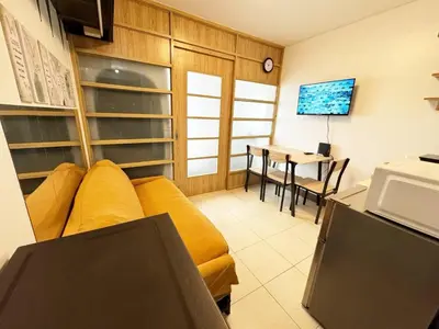 a living room with a yellow couch and a table at Fully Furnished 1BR Ridgewood Towers with 200Mbps WIFI in Manila