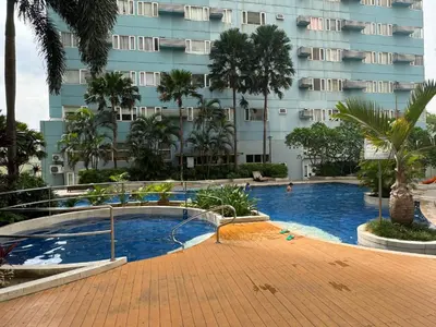 a swimming pool in front of a building at Fully Furnished 1BR Ridgewood Towers with 200Mbps WIFI in Manila