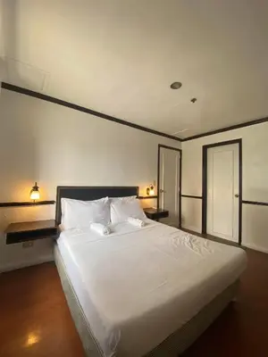 a large white bed in a room with two lamps at Fernandina 88 Suites Condo in Manila
