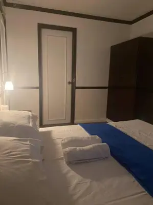 a bedroom with two white beds and a door at Fernandina 88 Suites Condo in Manila
