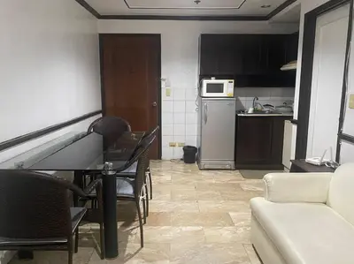 a living room with a table and a kitchen at Fernandina 88 Suites Condo in Manila