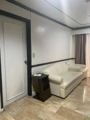 a living room with a couch and a door at Fernandina 88 Suites Condo in Manila