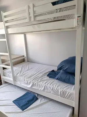 a white bunk bed with two blue pillows on it at Lorde's Hideaway in Manila