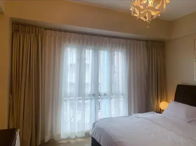 a bedroom with a bed and a large window at Newport City Family Suite near NAIA T3 in Manila