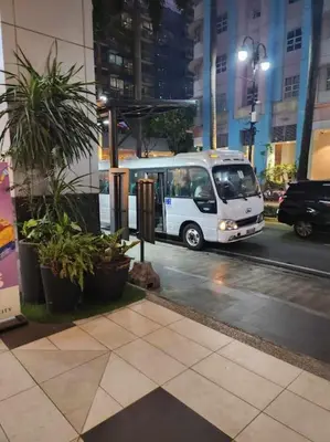 a white van driving down a city street at night at Newport City Family Suite near NAIA T3 in Manila