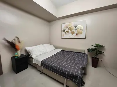 a bedroom with a bed and a picture on the wall at Newport City Family Suite near NAIA T3 in Manila