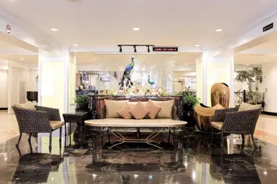 a lobby with a couch and a table and chairs at Las Palmas Hotel de Manila in Manila