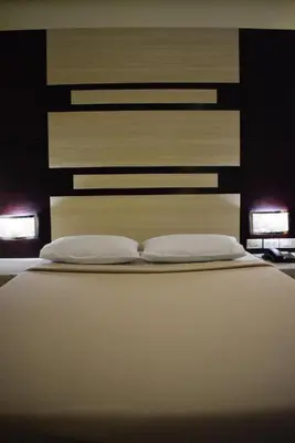 a bedroom with a bed with two pillows at Vista Hotel Cubao in Manila