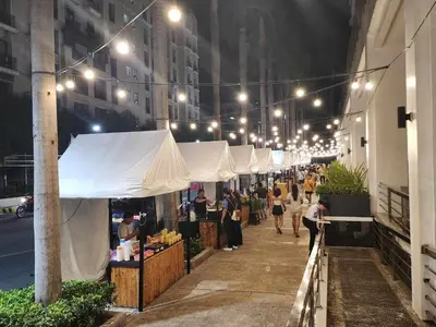 a group of people walking down a street at night at 1 Bed Apartment - Sleeps 7 - Pool & Wifi in Manila