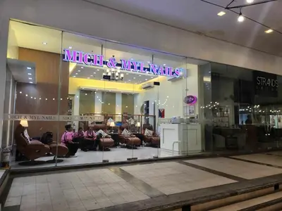 a mall with people sitting in chairs in a store window at 1 Bed Apartment - Sleeps 7 - Pool & Wifi in Manila