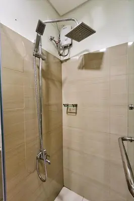 a shower with a shower head in a bathroom at Cozy Deluxe Double Twin Beds-MOA Pasay Shore 2-T1 in Manila