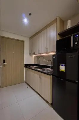 a kitchen with a sink and a black refrigerator at Cozy Deluxe Double Twin Beds-MOA Pasay Shore 2-T1 in Manila