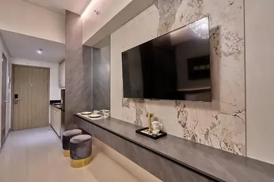 a living room with a television on a wall at Cozy Deluxe Double Twin Beds-MOA Pasay Shore 2-T1 in Manila