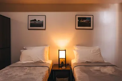 a room with two beds and a light on the wall at The City Flats Circuit in Manila