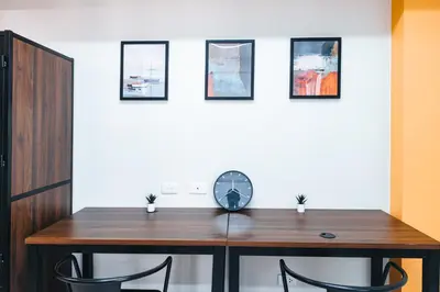a dining room table with two chairs and a clock at The City Flats Circuit in Manila