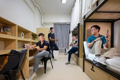 a group of young men sitting in bunk beds at The City Flats Circuit in Manila