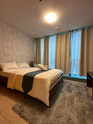 a bedroom with a large bed and a large window at BGC One Uptown Suite by Christine Suites PH in Manila
