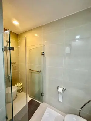 a bathroom with a shower with a toilet and a sink at BGC One Uptown Suite by Christine Suites PH in Manila
