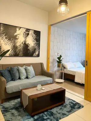 a living room with a couch and a bed at BGC One Uptown Suite by Christine Suites PH in Manila