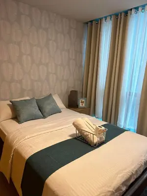 a bedroom with a large bed and a window at BGC One Uptown Suite by Christine Suites PH in Manila