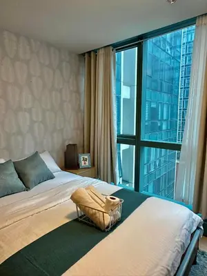 a bedroom with a bed and a large window at BGC One Uptown Suite by Christine Suites PH in Manila