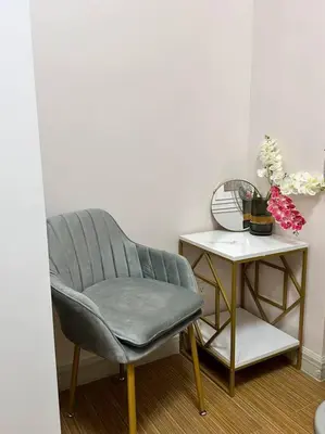 a chair sitting next to a side table with a side table at Cozy Condo in Taguig in Manila