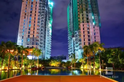 two tall buildings next to a river at night at Lovely two bedroom apartment with balconies in Manila
