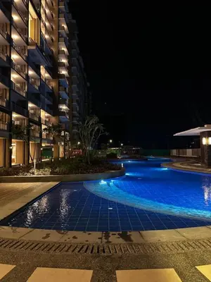 a large swimming pool at night with a building at Satori Residence in Manila