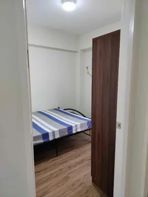 a small room with a bed and a closet at Satori Residence in Manila