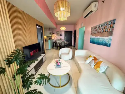 a living room with a white couch and a tv at Elegant 4BR with balcony and bathtub in Uptown BGC in Manila