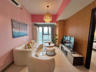 a living room with a couch and a tv at Elegant 4BR with balcony and bathtub in Uptown BGC in Manila