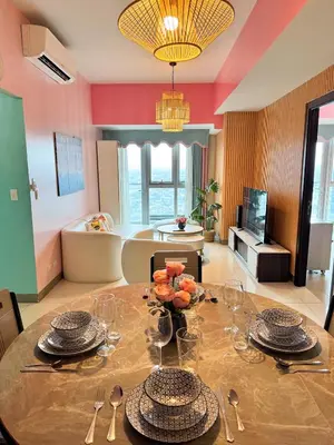 a dining room with a table with plates and glasses at Elegant 4BR with balcony and bathtub in Uptown BGC in Manila