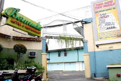 a building with a motorcycle parked in front of it at Bermuda Hotel in Manila