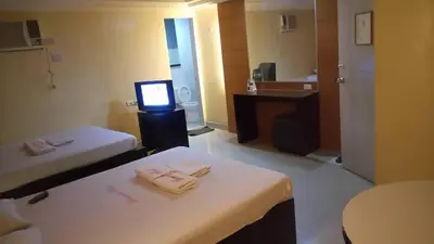 a hotel room with two beds and a television at Bermuda Hotel in Manila