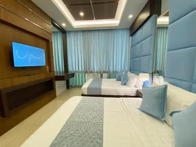 a hotel room with a bed and a flat screen tv at UPad Hotel in Manila