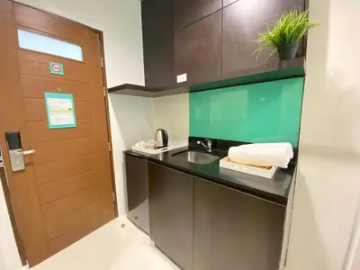 a bathroom with a sink and a wooden door at UPad Hotel in Manila