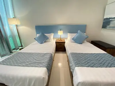 a bedroom with two beds with blue pillows at UPad Hotel in Manila