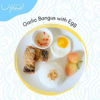 a plate of food with eggs and rice and fruit at UPad Hotel in Manila